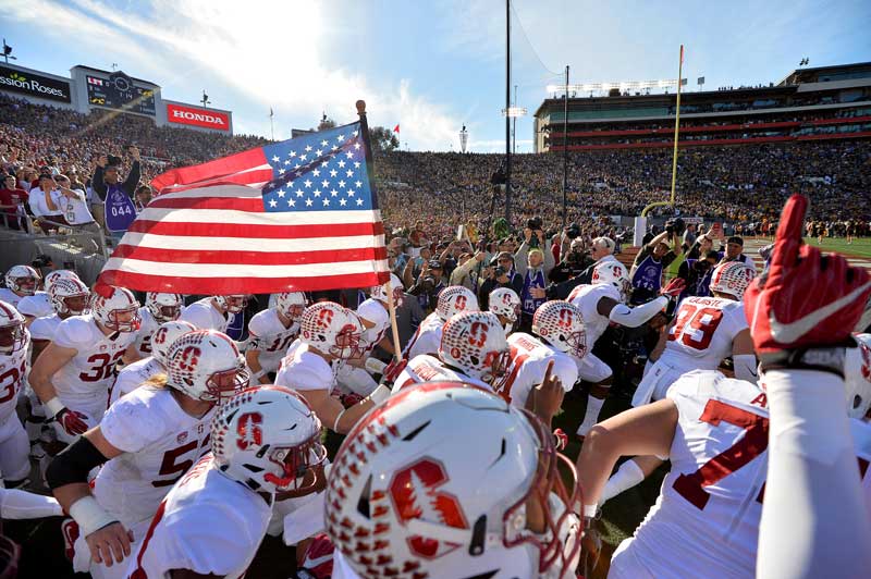 Players enter the field carrying an American flag