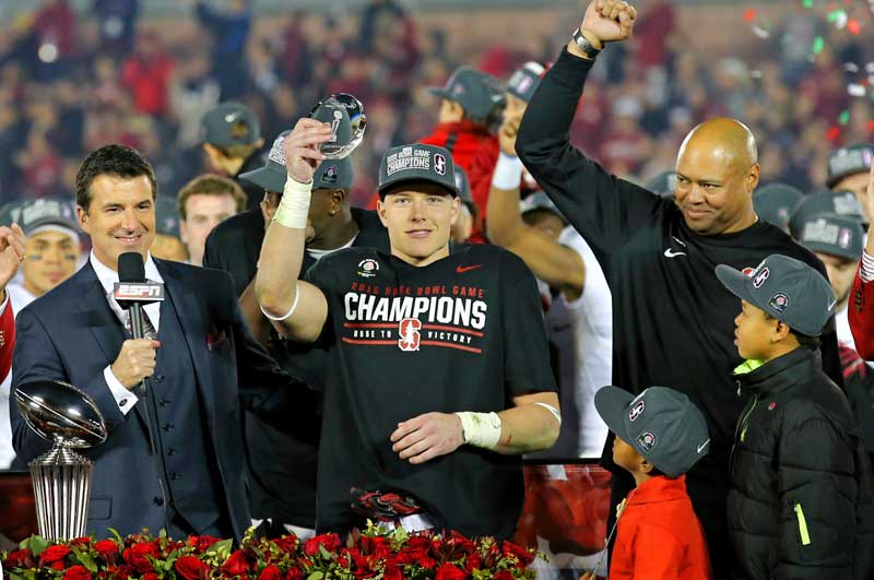 Christian McCaffrey holding his award with Coach Shaw behine him