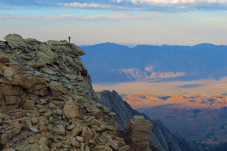 Stanford Earth alum Hari Mix standing atop the Sierra Nevada