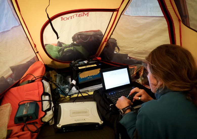 Lauren Oakes entering data in tent