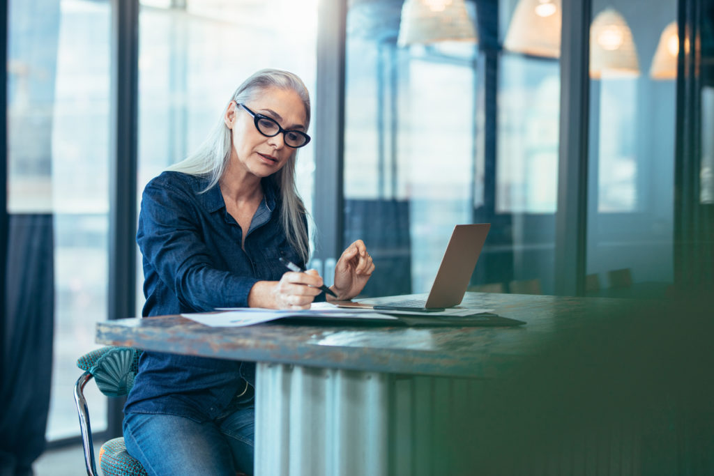 Portrait of senior woman using a laptop in an office..