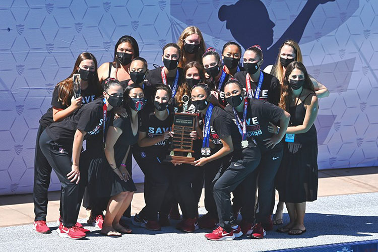 Women in masks holding trophy