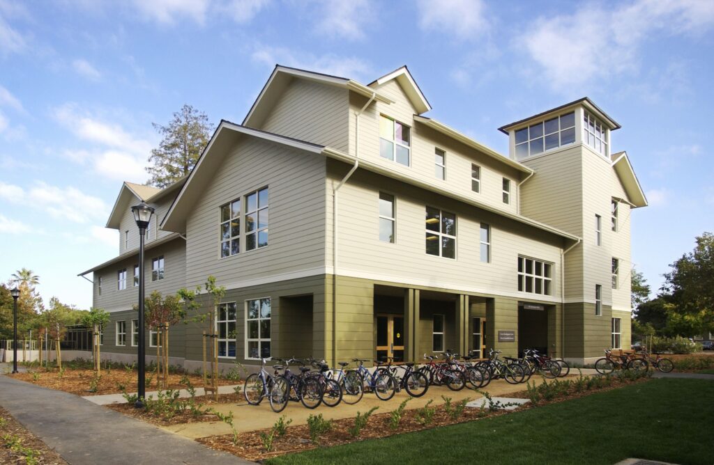 Shows the building where BEAM is located, three stories, tan siding.