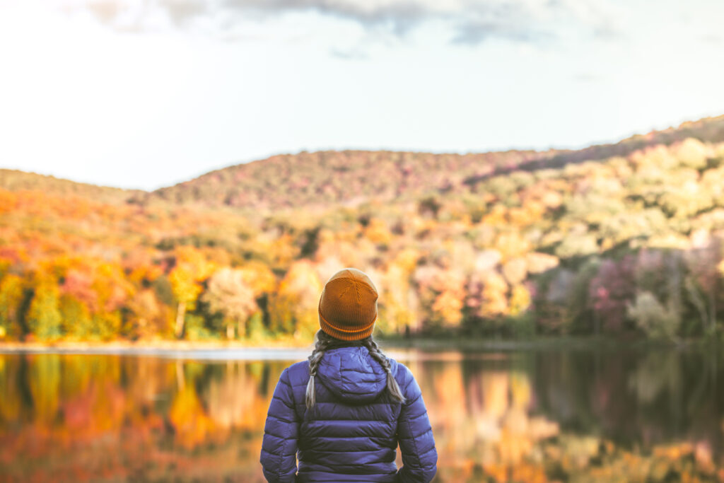 Young woman alone in nature surrounded by beautiful autumn colors.