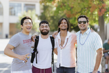 Four students standing arm-in-arm.