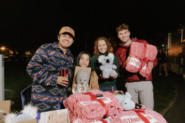 Four students at a table with packages.