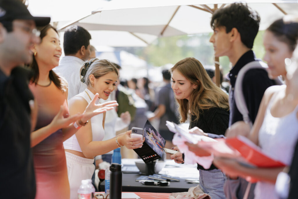 Students and employers under shade umbrellas at an outdoor career fair on White Plaza