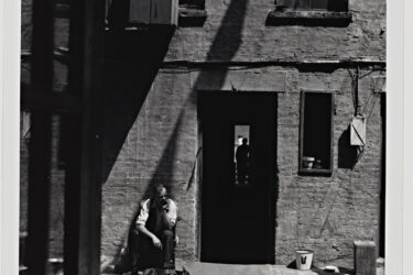 Aaron Siskind’s photography series on St. Joseph’s House, a shelter run by the Catholic Worker Movement in New York, gently draws our attention to small details. Perhaps none are more delightful than the French Bulldog basking in the sun at the feet of his human companion.