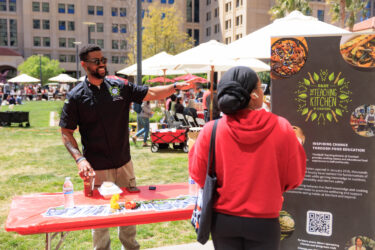 Staff members speaking to a student at a table.