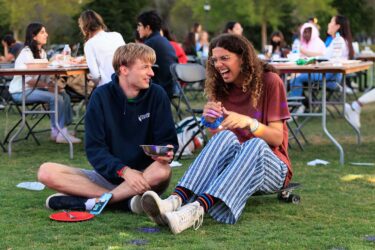 Two students seated on the lawn.