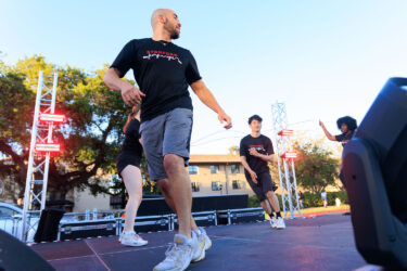 Three students jumping rope on stage.