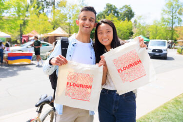 Two students with tote bags.