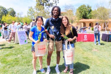 Three students with tote bags.