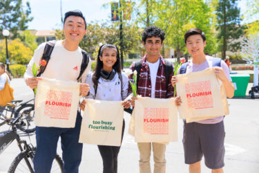 Four students with tote bags.