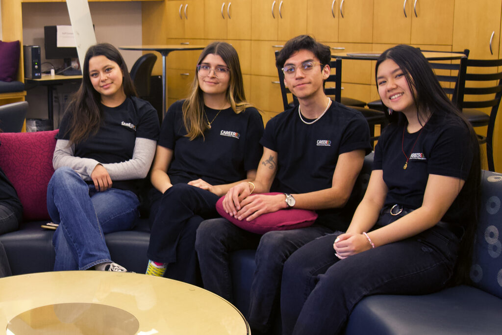 Four peer counselors in CareerEd shirts seated for a group shot