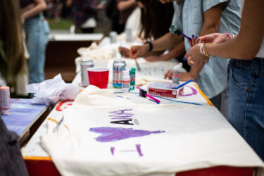 Student decorating a t-shirt with the letter A and Aspen.