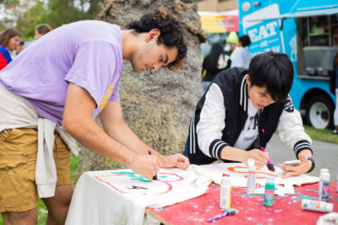 Students at a table decorating t-shirts.