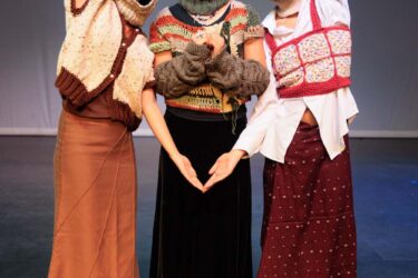 Three students in modified traditional attire.