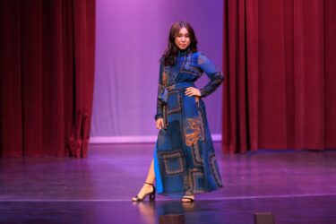 Model in floor length blue dress.