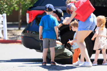 A police officer helps children get fingerprinted.