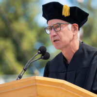 close-up of John McEnroe at lectern delivering Commencement address in Stanford Stadium June 18, 2023