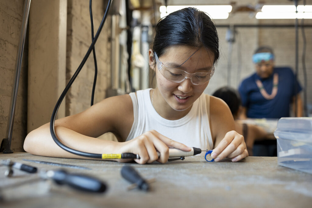 Undergraduate student Vanessa Chen works on a jewelry project during the Arts Intensive program.