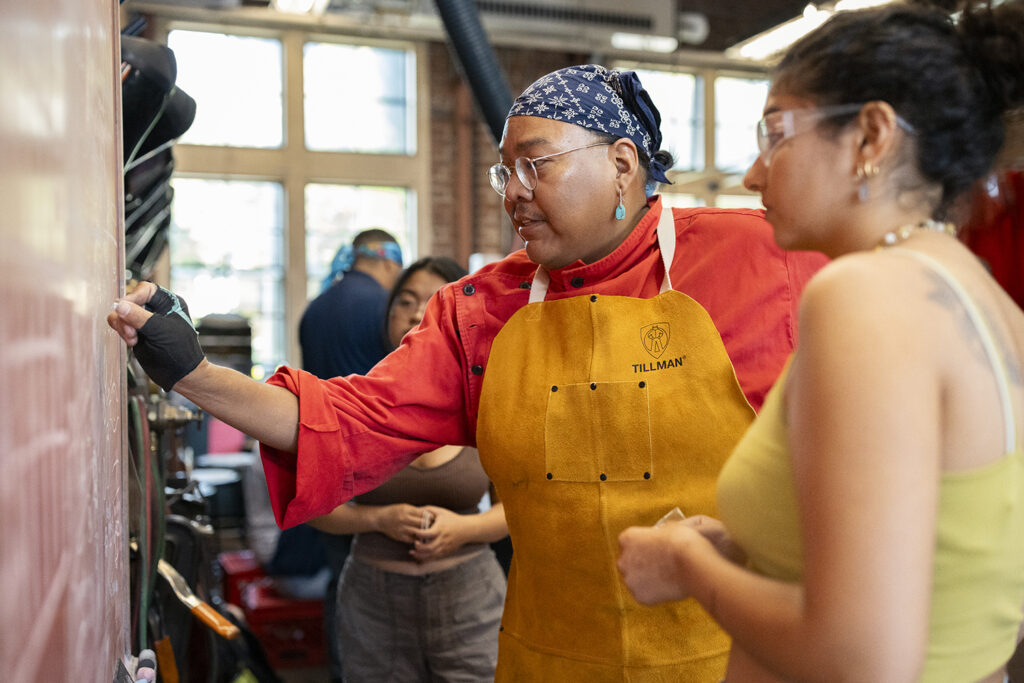 Artist Zefren Anderson at the blackboard with Arts Intensive students.