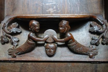 This 13th century misericord in Exeter Cathedral depicts a mermaid and a merman holding a drum or cymbal.