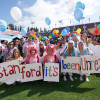 students in costume holding a sign that reads "Stanford - It's been unreal"