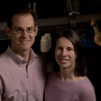 A man and woman stand together in a lab.