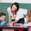 teacher assisting elementary grade students / racorn/Shutterstock