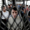 Immigrants on a U.S. Immigration and Customs Enforcement bus heading for deportation / AP Photo/LM Otero