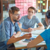 students talking around a table / Pressmaster/Shutterstock