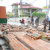 people clearing bricks from a fallen wall following April Nepal quake / Jeevan Ale