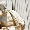 Statue of ancient philosopher holding a scroll. / Photo: Shutterstock