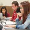 students with papers and laptop computers at a table / L.A. Cicero