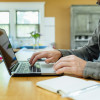 hands typing at a laptop computer / massimo colombo/iStock