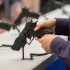 hands holding a gun at display desk