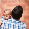 father carrying baby on his shoulder