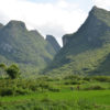 Karst mountains in China with farmer in field.