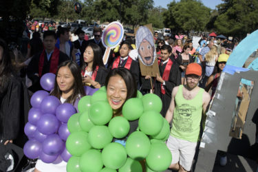 Students wearing balloons crowd near the gate to Stanford Stadium before Wacky Walk