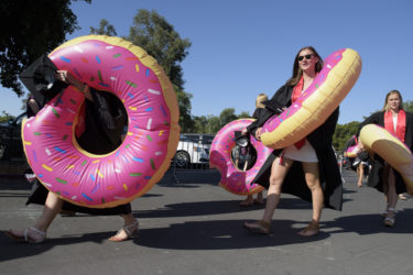 The women's swim team wear giant inflatable doughnut life preservers to the Wacky Walk