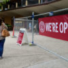 construction fence at Tresidder Memorial Union with 'We're Open' banner