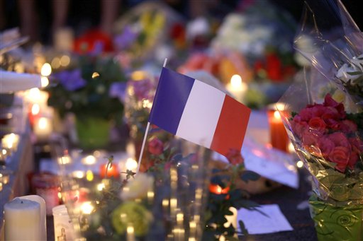 French flag amid candles and flowers