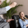 Male therapist using hypnosis therapy on young woman