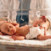 Tiny baby in a incubator with a medical person standing behind