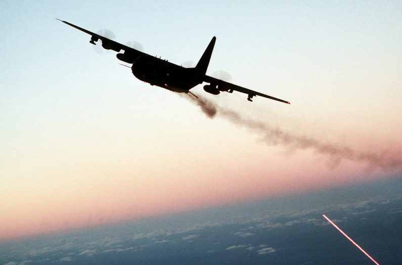 An AC-130 Hercules aircraft banks to the left