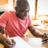 man doing paperwork at the kitchen table