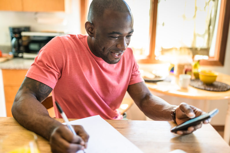 man doing paperwork at the kitchen table