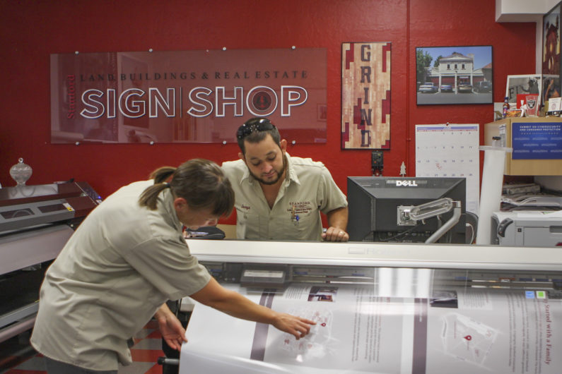 Suzy Huizinga and Jorge Granados of the Sign Shop print out signs for the new interpretive kiosks.